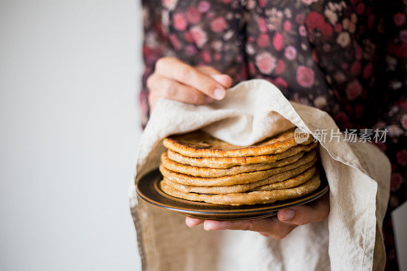 妇女拿着传统的印度面包- Aloo paratha或aalu paratha，土豆填充面包